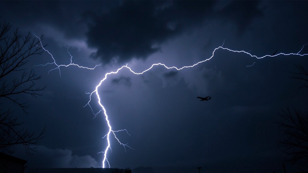 A dramatic image of lightning illuminating a dark sky, with a plane flying in the distance.