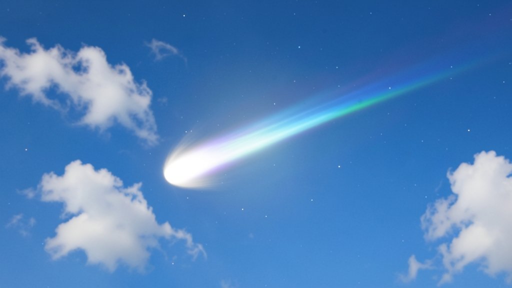 A high-resolution image of a comet in the sky, with a bright tail and a clear view of the stars in the background, during daytime with a blue sky and a few clouds.